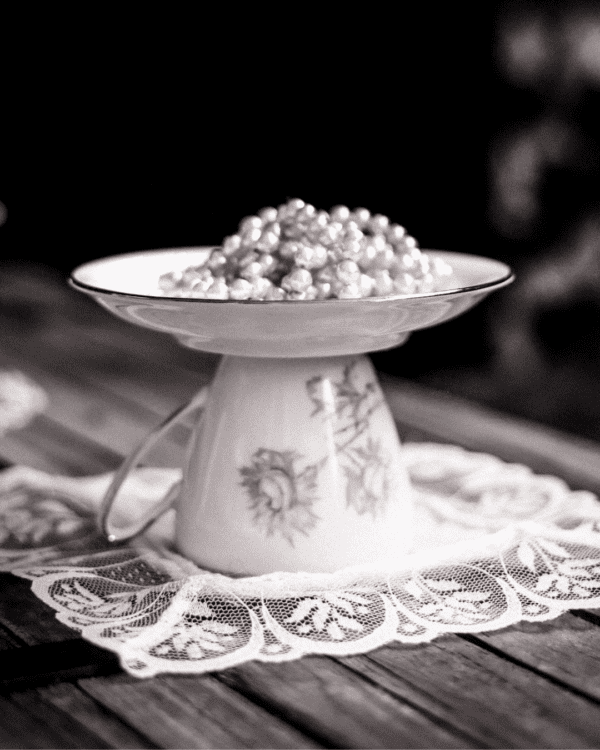 Jabonera curiosa y vintage hecha con taza y plato de porcelana con flores, dandoles una segunda vida, sobre encaje blanco