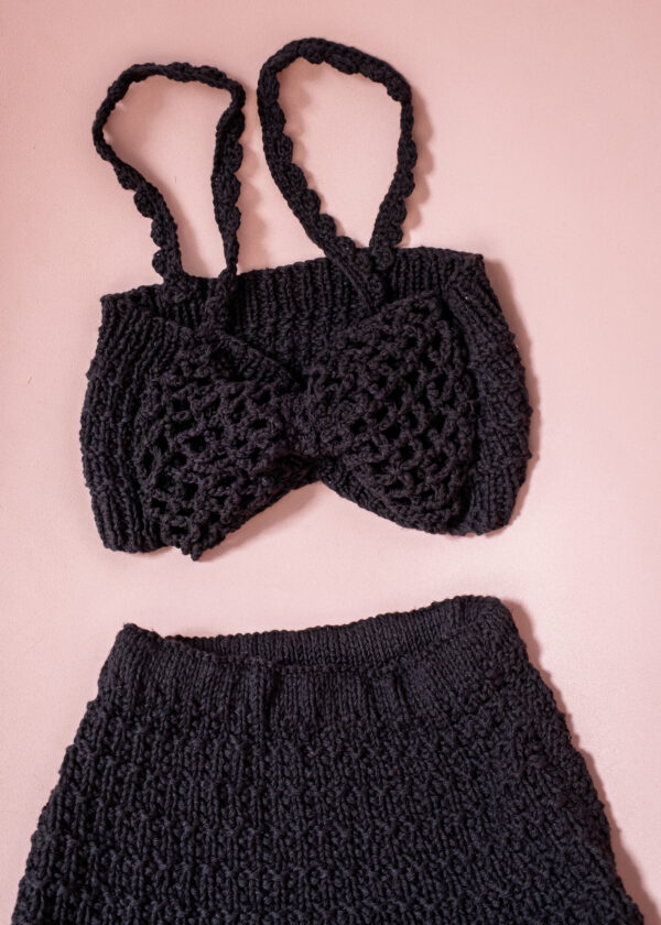 Conjunto de top y culote de punto sobre superficie rosa con gran lazo