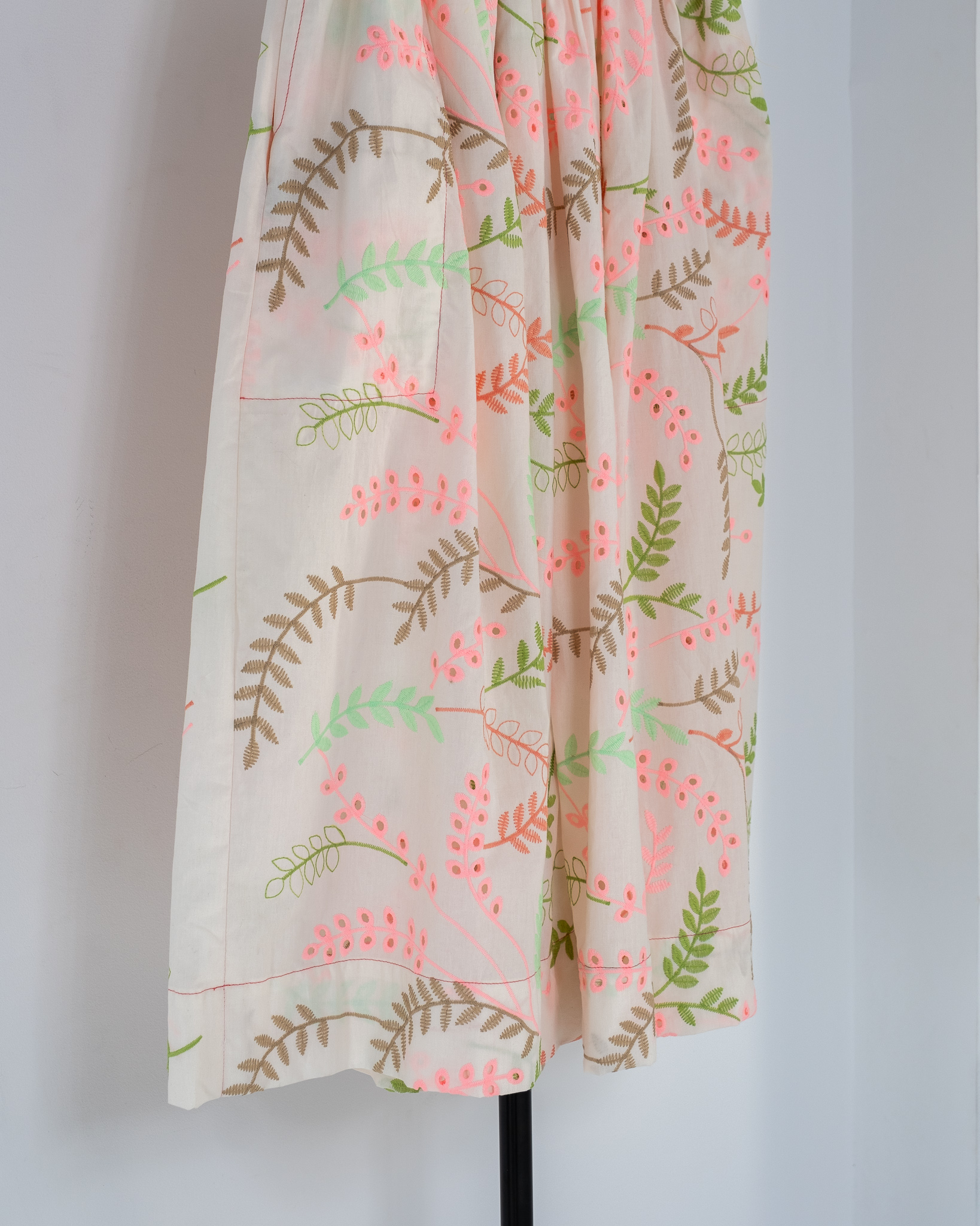 Falda con vuelo en bordado suizo blanco con estampado de hojas en tonos rosa, verde y beige, modelo Sister Laura de The Curiousers
