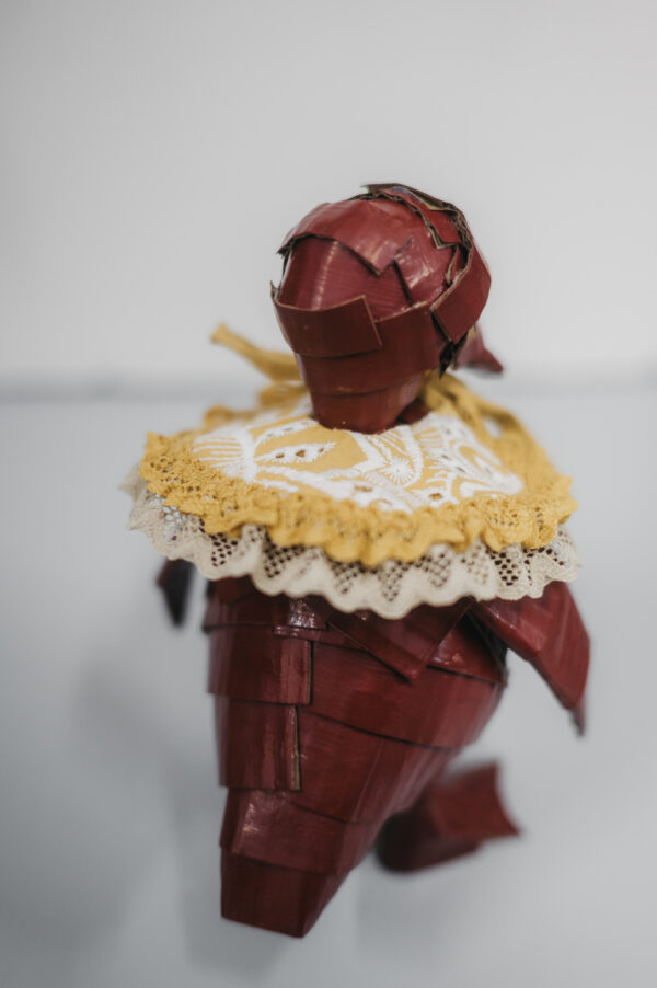 Escultura de cartón de un patito color burgundy con cuello amarillo de The Curiousers meet Cova Orgaz