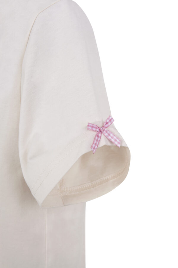 Detalle del lazo de vichy rosa aplicado artesanalmente en la manga de la camiseta Lady Soy Curiouser de The Curiouser